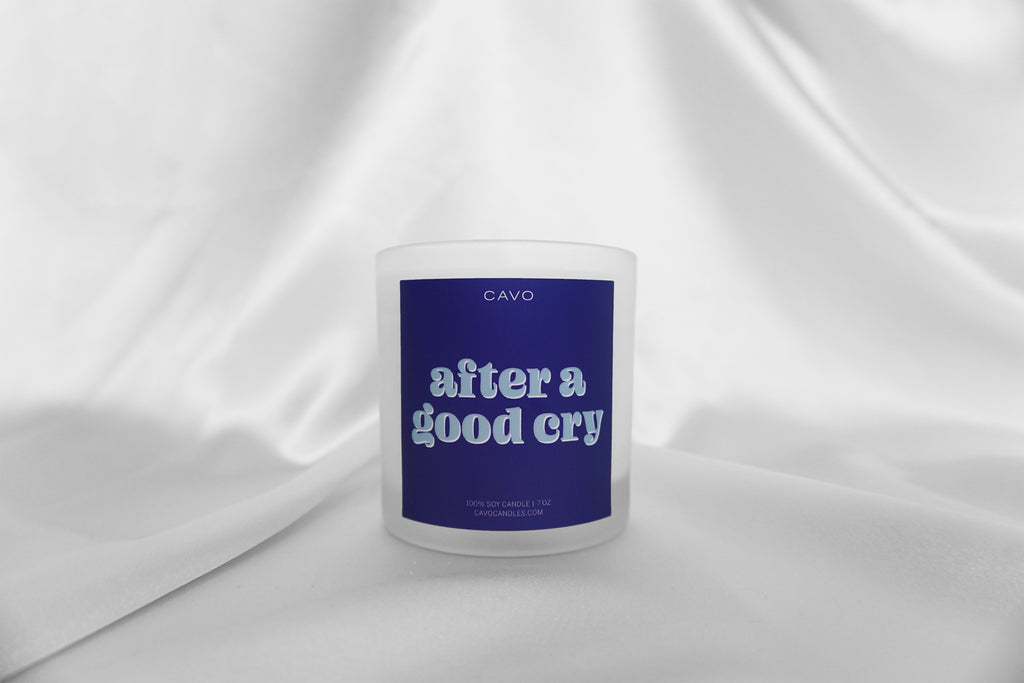 100% Soy, Vegan, Non-Toxic Black Women Owned Candle in Frosted White Jar. Royal Blue Label read "After A Good Cry" in light blue font.